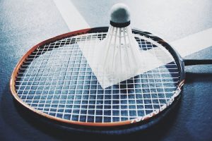 Badminton Racket laying on court with shuttlecock